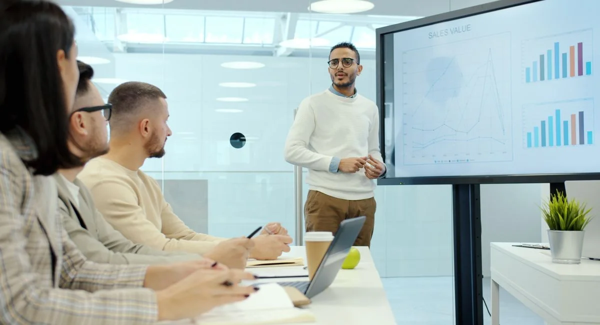 Business team in a modern office, discussing charts during a presentation.